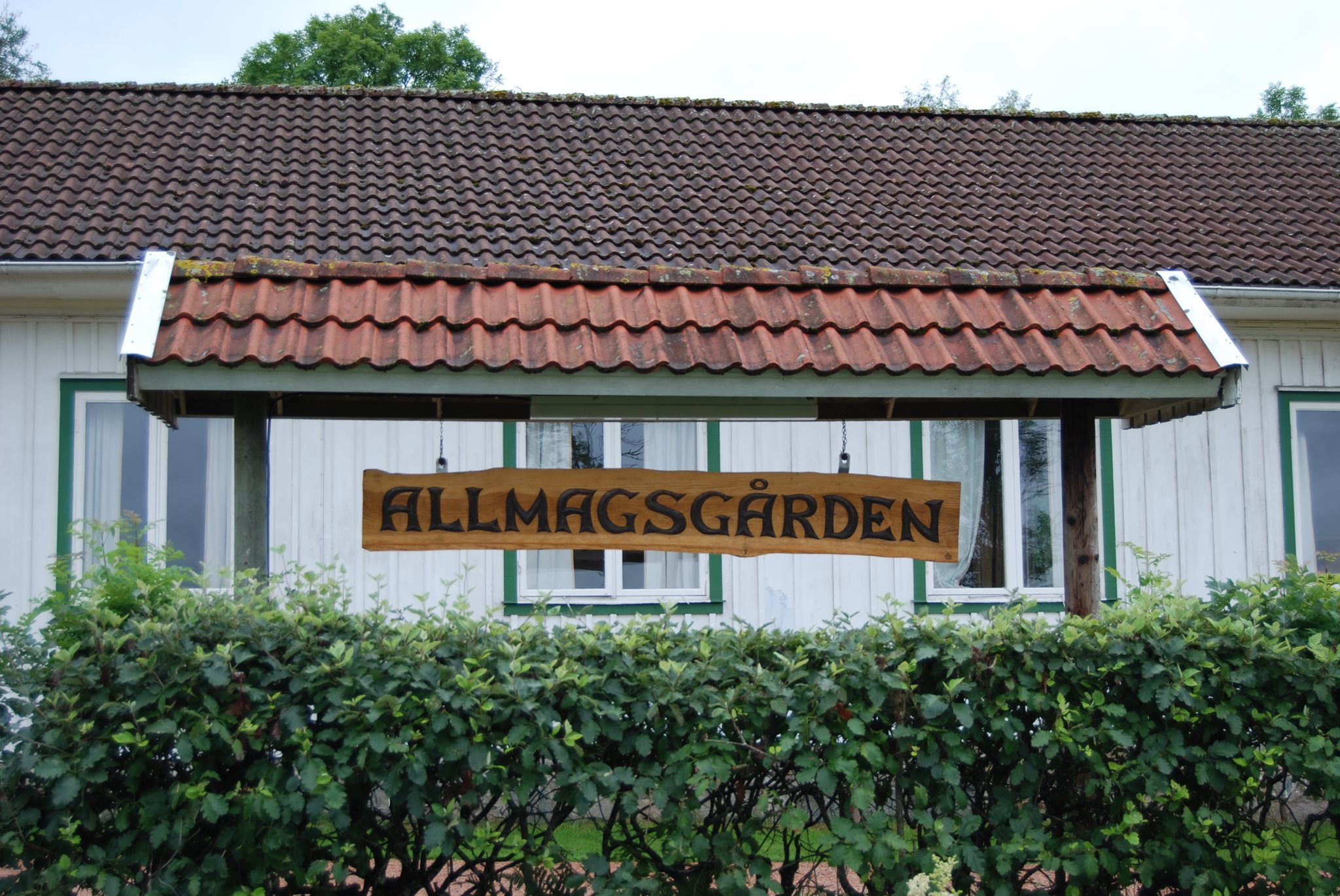 Entrén till Allmagsgården med dess träskylt